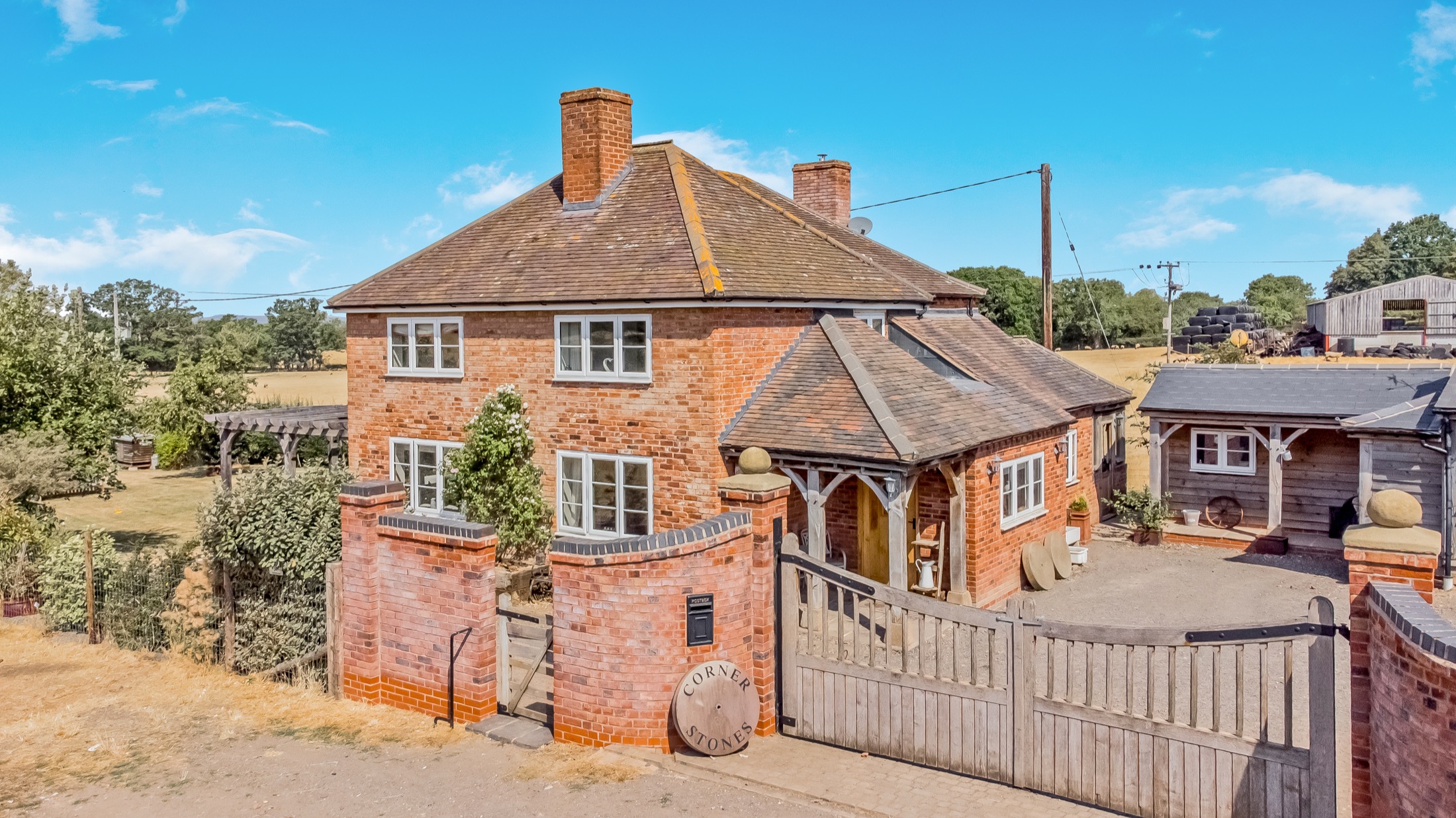 Aerial view of a red brick farmhouse and outbuildings