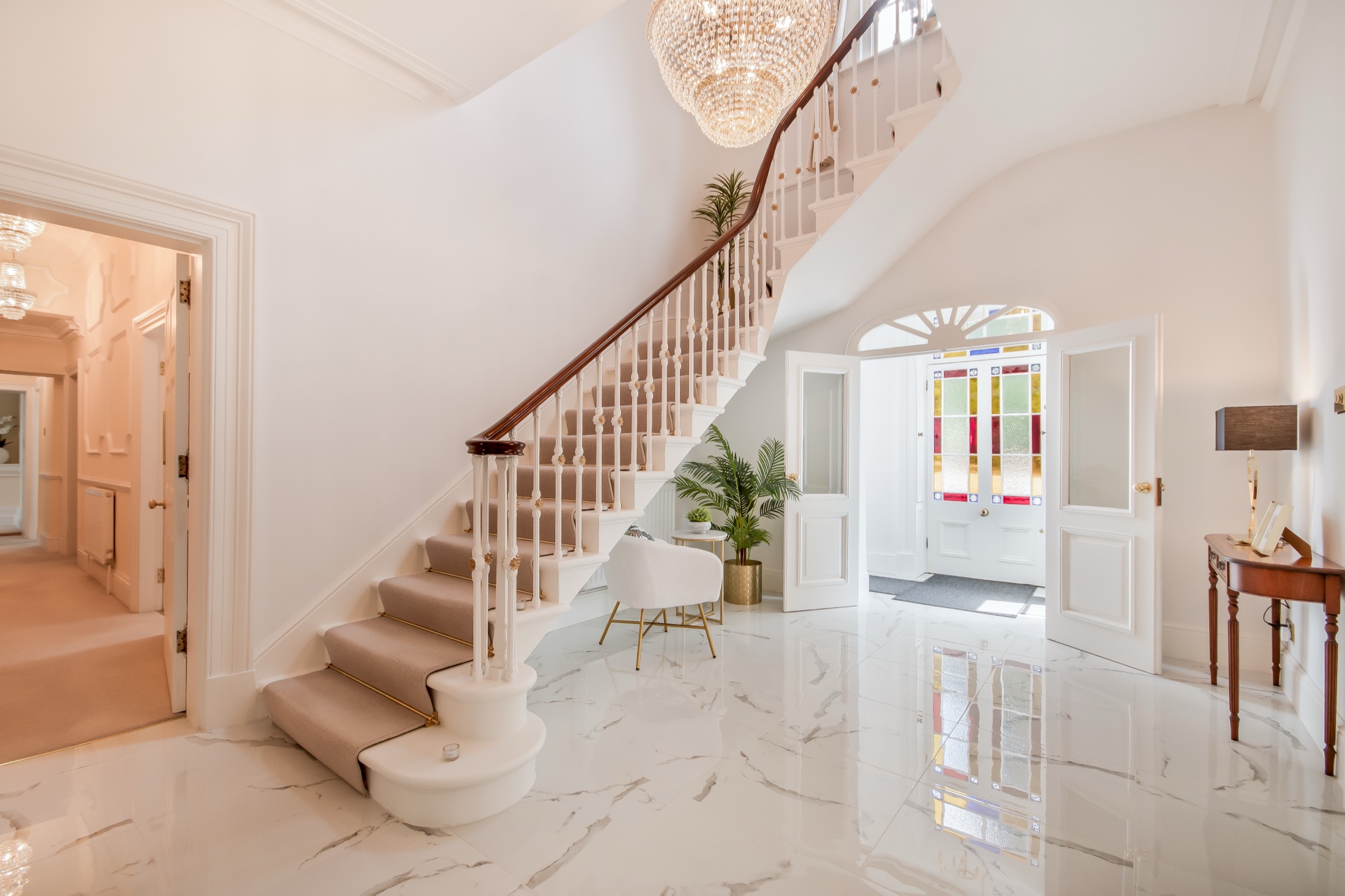 Entrance hall with marble floor and sweeping staircase