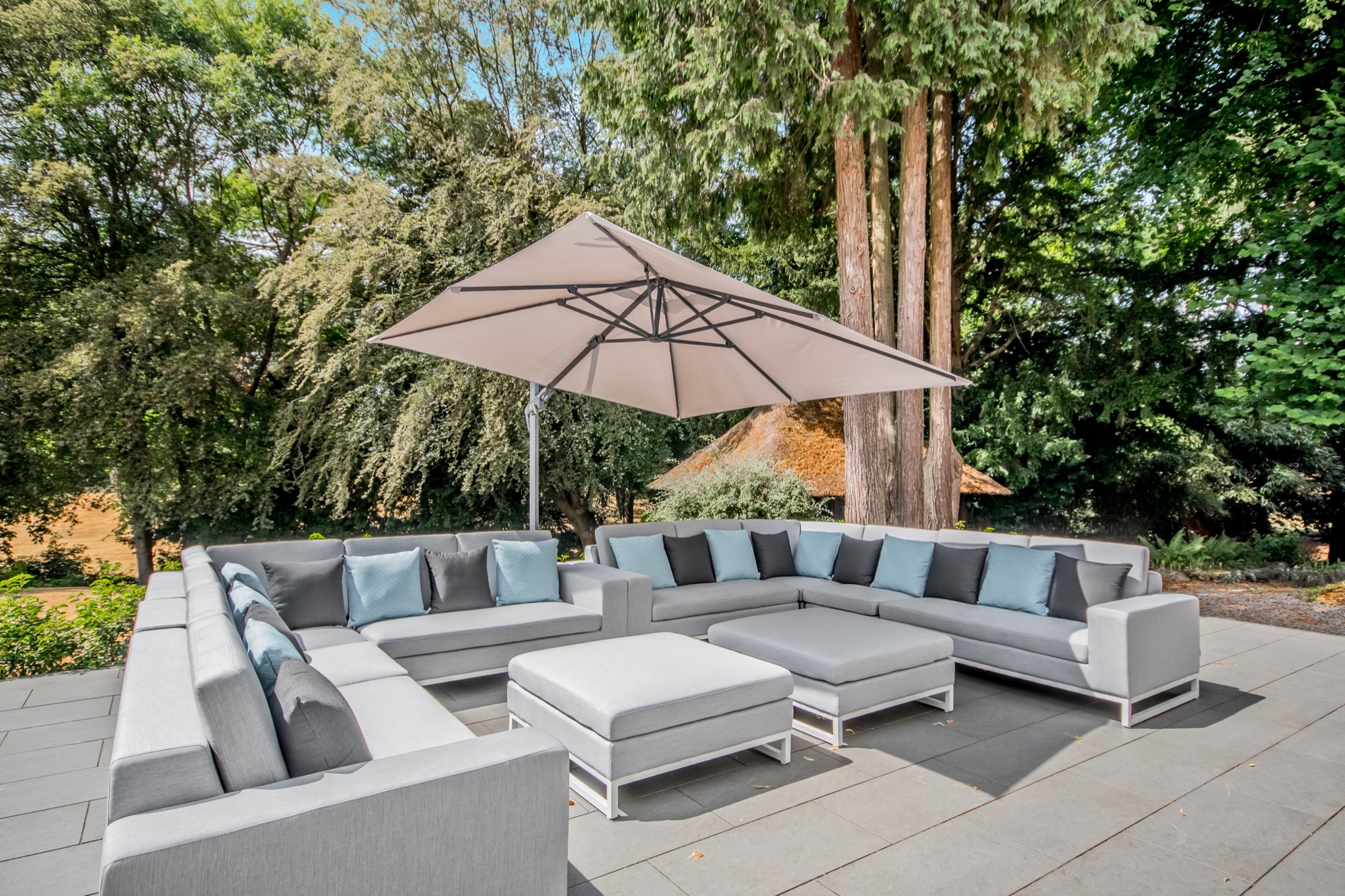 Paved terrace with outdoor seating beneath a parasol