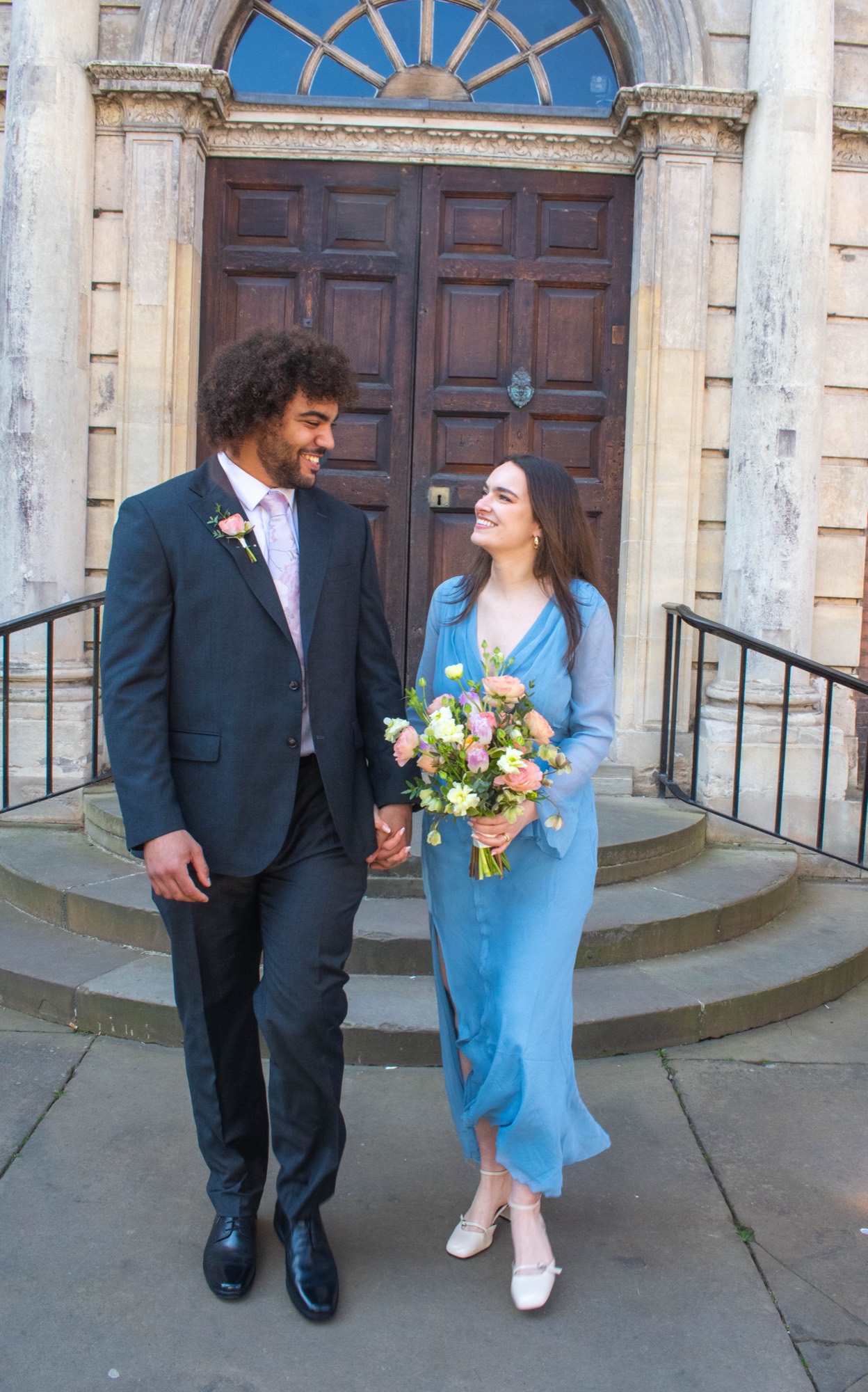 A couple walking down the steps after their ceremony